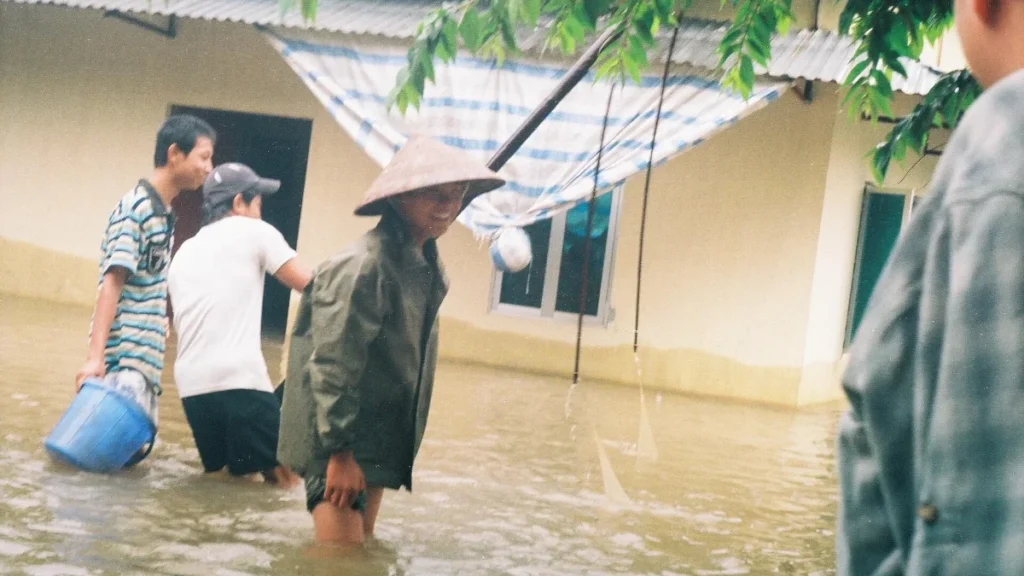 Người dân lội nước lũ ngập sân nhà