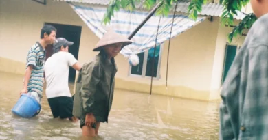 Người dân lội nước lũ ngập sân nhà