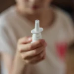 Trẻ cầm lọ thuốc xịt mũi nhỏ