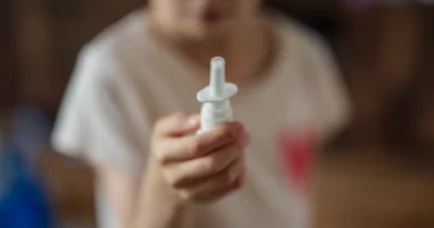 Trẻ cầm lọ thuốc xịt mũi nhỏ
